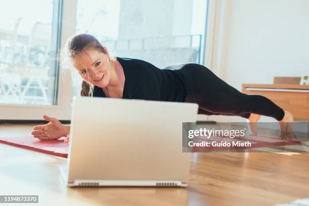woman doing sport in front of laptop. - sports training stock pictures, royalty-free photos & images