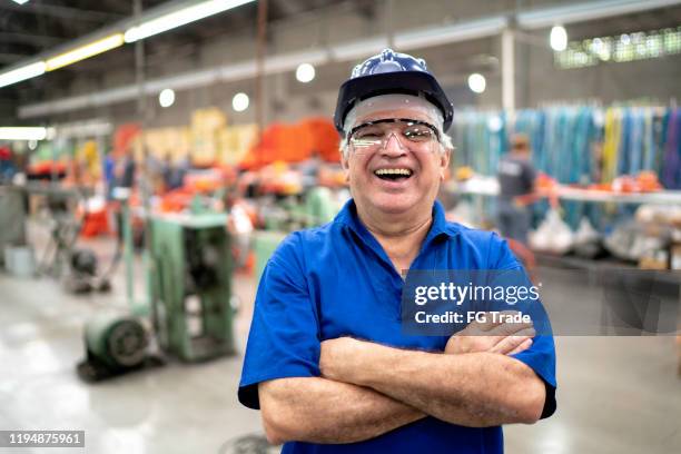 portrait of a happy engineer using protective workwear while working in a factory - production line worker stock pictures, royalty-free photos & images