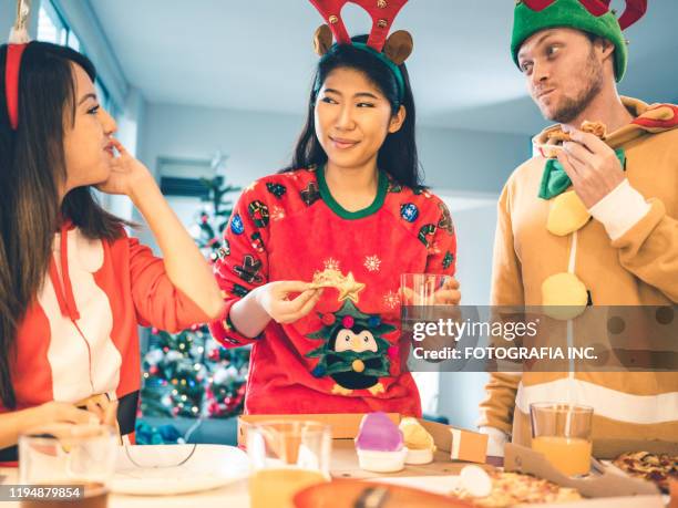 millennial weihnachts-pizza-party - weihnachtspullover stock-fotos und bilder