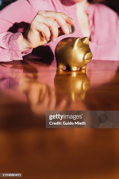 putting a coin in a piggy bank at home. - euro in hand bildbanksfoton och bilder