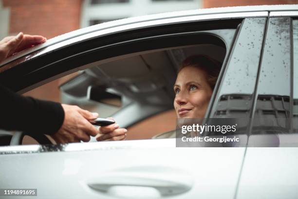 hier is uw sleutel - luxeauto stockfoto's en -beelden