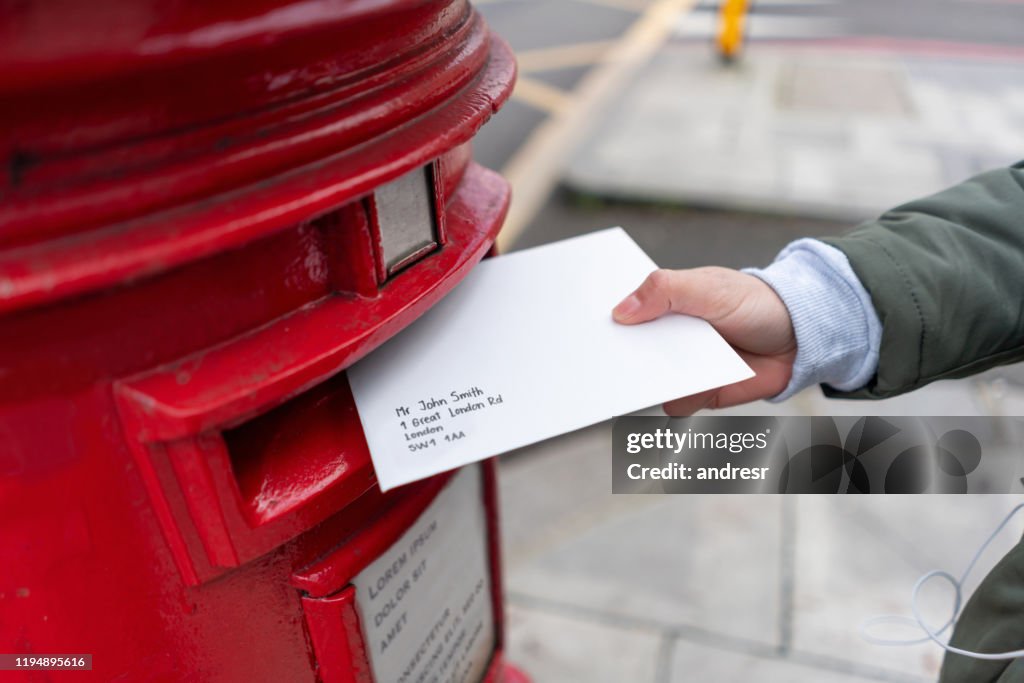 Close-up on a woman sending a letter by mail