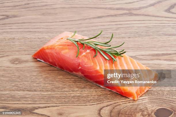 fresh raw salmon fillet with rosemary leaf on a wooden background - rustic salmon fillets stock pictures, royalty-free photos & images