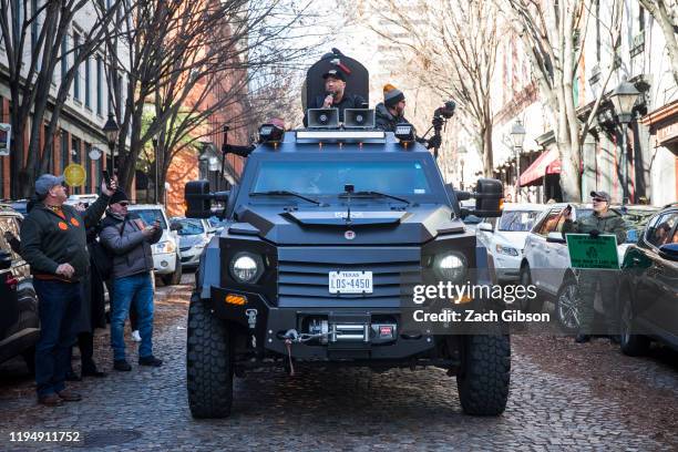 InfoWars host Alex Jones rides in an armored vehicle during a rally organized by The Virginia Citizens Defense League on Capitol Square near the...