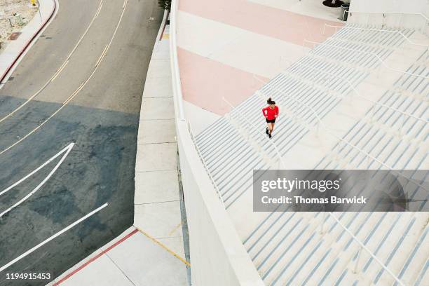 overhead view of mature woman running stairs during workout - hartnäckigkeit stock-fotos und bilder