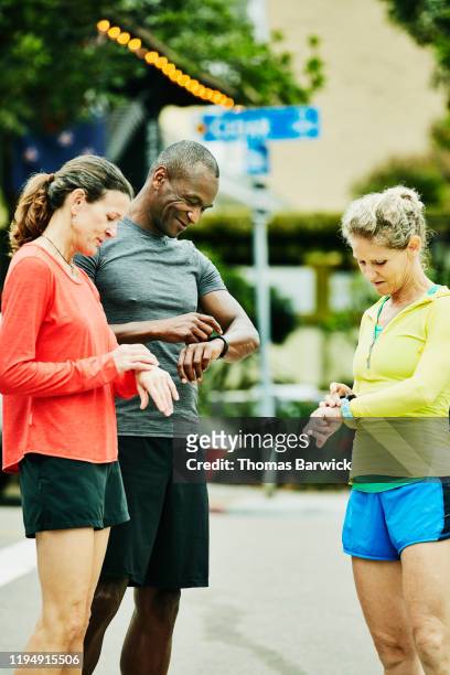 Mature friends checking smart watches before morning run