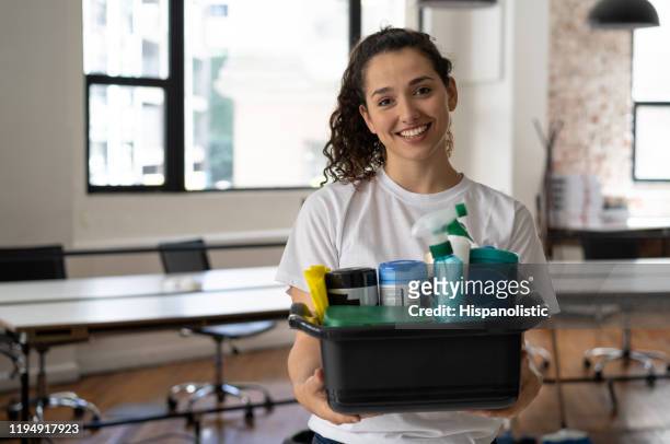ritratto di bella donna più pulita che tiene in mano un secchio con prodotti per la pulizia in un ufficio sorridente alla telecamera - bidello foto e immagini stock