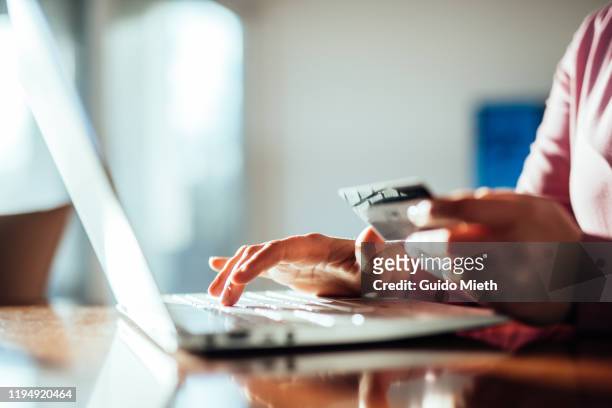 woman shopping online with a credit card and pc. - internet stockfoto's en -beelden