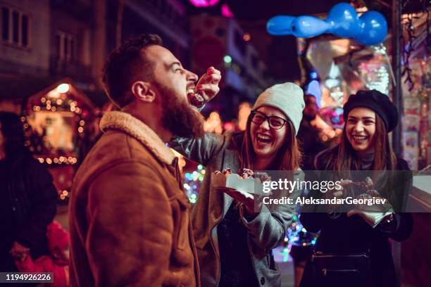 females feeding donuts to their male friend - chocolate expo stock pictures, royalty-free photos & images