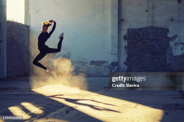 silueta de bailarina bailando en edificio abandonado - ballet shoes silhouette fotografías e imágenes de stock