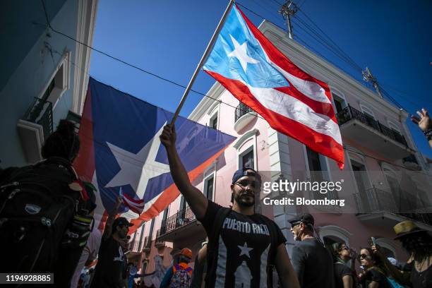 Demonstrators wave Puerto Rican flags during a protest against the government in San Juan, Puerto Rico, on Monday, Jan. 20, 2020. People in a...