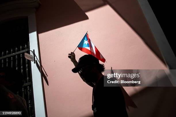 Demonstrator waves a Puerto Rican flag during a protest against the government in San Juan, Puerto Rico, on Monday, Jan. 20, 2020. People in a...