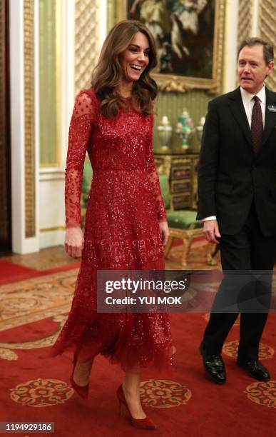 Britain's Catherine, Duchess of Cambridge walks through to the State Room with the Master of the Household at a reception for heads of State and...