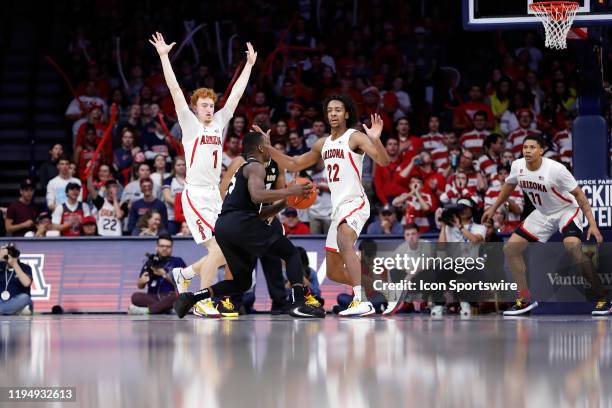 Colorado Buffaloes guard McKinley Wright IV is defended by Arizona Wildcats guard Nico Mannion and forward Zeke Nnaji during the second half of the...