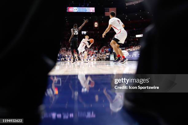 Arizona Wildcats guard Nico Mannion passes to forward Ira Lee while being defended by Colorado Buffaloes guard McKinley Wright IV during the second...