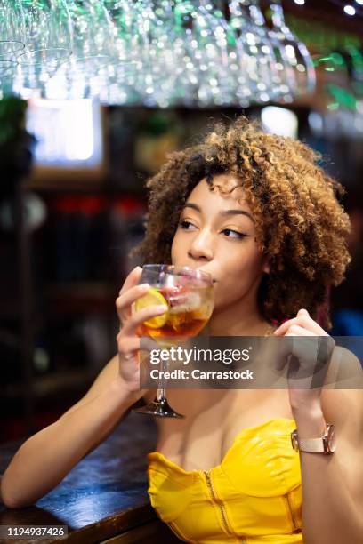 beautiful afro woman drinking a soda in nightclub. - barman tequila stockfoto's en -beelden