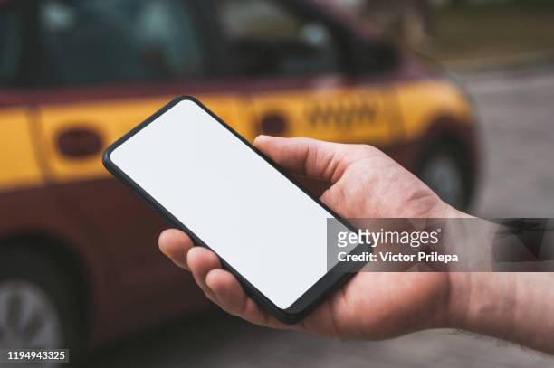 mock up of a smartphone in hand, on the background of a taxi car. - car display background stock-fotos und bilder
