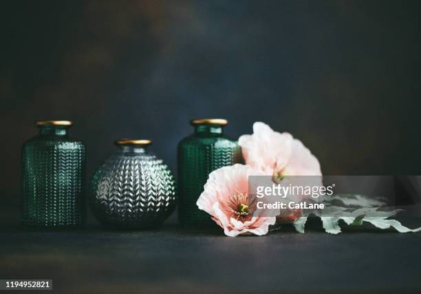 still life background with small glass jars and pink poppies - poppies in vase stock pictures, royalty-free photos & images