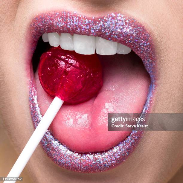 shimmering lips biting on lollipop - candy on tongue stock pictures, royalty-free photos & images