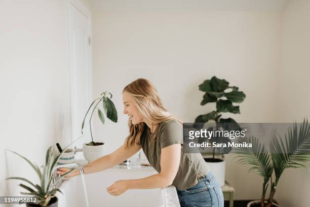 woman washing hands in sink - woman in bathroom stock pictures, royalty-free photos & images