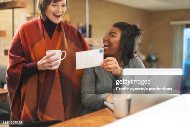 mother and adopted african american daughter getting news on college funding at home - draft media opportunity stock pictures, royalty-free photos & images