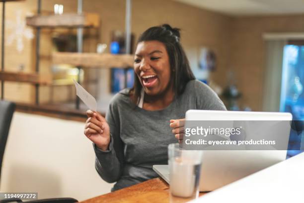 african american generation z female getting news on college funding at home - debit cards credit cards accepted stock pictures, royalty-free photos & images