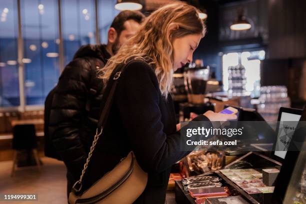 coffee buying women in the coffee shop - mobile app coffee ordering - customers lining up stock pictures, royalty-free photos & images