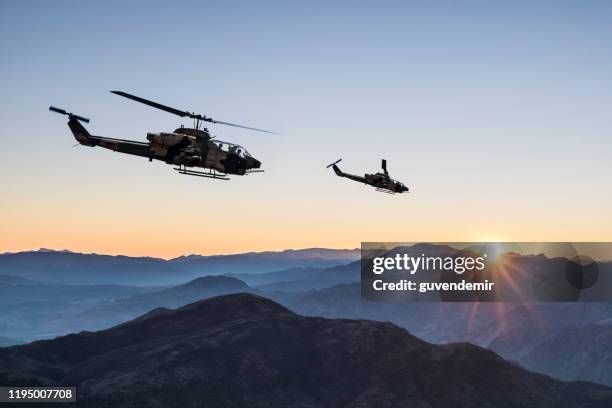 helicópteros ah-1 cobra attack sobrevolando montañas al amanecer - ah 1 cobra fotografías e imágenes de stock