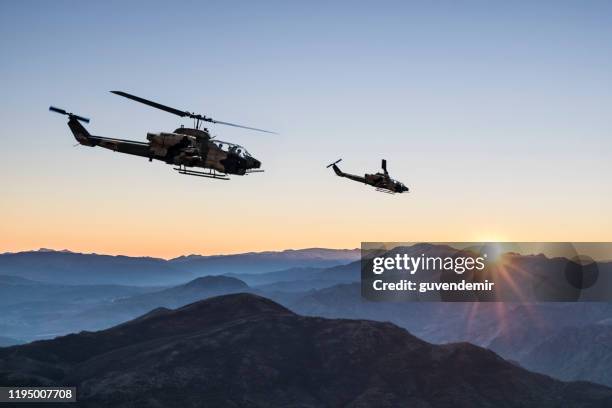 helicópteros ah-1 cobra attack sobrevolando montañas al amanecer - military helicopter fotografías e imágenes de stock