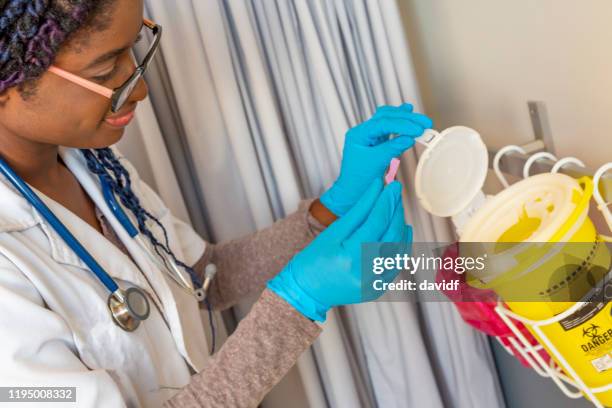 kvinnlig läkare kassera säkert vassa avfall - behållare för farligt avfall bildbanksfoton och bilder
