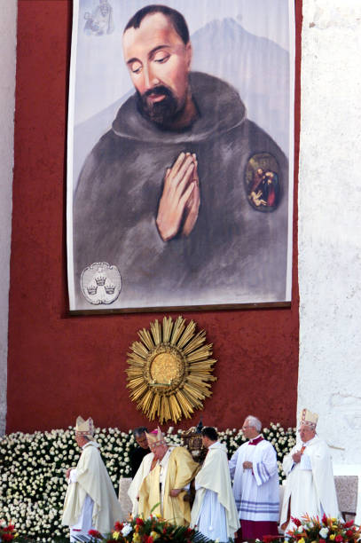 Pope John Paul II is seated under a photo of Pedro de San Jose Betancur after arriving at Mass July 30, 2002 in Guatemala City, Guatemala. The pope...