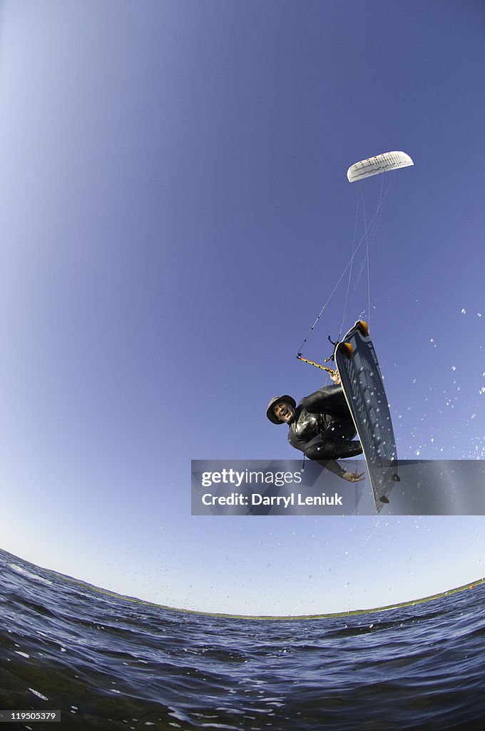 Mature man jumping on kiteboard