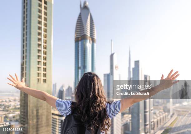 tourists open their arms and look forward to the city of dubai - ドバイ　ホテル ストックフォトと画像