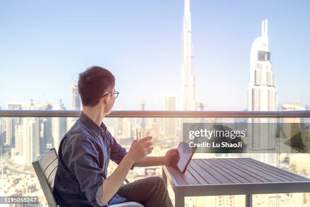 tourist spend time sitting on the balcony of the dubai luxury hotel. - luxury location stock pictures, royalty-free photos & images