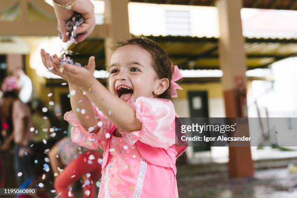 hübsches mädchen bläst konfetti - fiesta stock-fotos und bilder