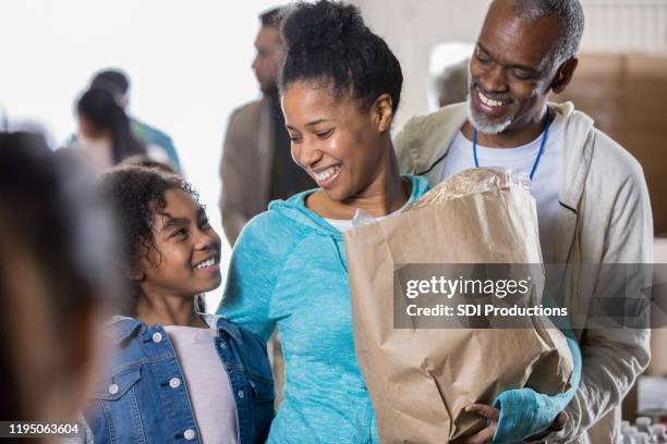 relieved woman receives food from food bank - source stock pictures, royalty-free photos & images