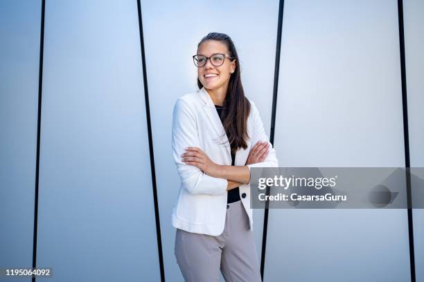 young businesswoman standing in front of a building with pride - stock photo - business courage stock pictures, royalty-free photos & images