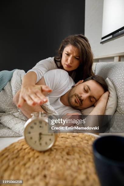 young woman turning off alarm clock - hitting alarm clock stock pictures, royalty-free photos & images