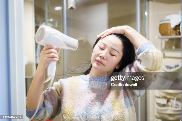 young asian female dry with  blower - hair dryer ストックフォトと画像