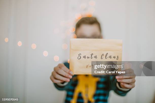 boy showing the letter to santa claus in christmas time - child writing letter to santa stock pictures, royalty-free photos & images