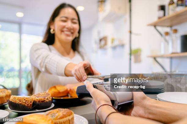 costumer making contactless payment in cafe - contactless payment stock pictures, royalty-free photos & images