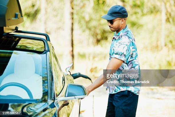 Man opening drivers door of electric car