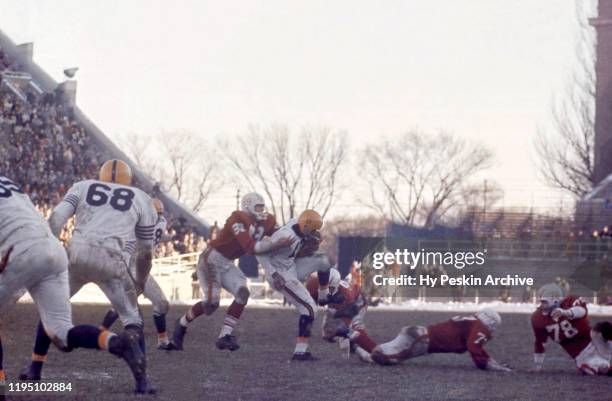 Mel Meyers of the Illinois Fighting Illini runs with the ball as Henry Derleth of the Wisconsin Badgers goes for the tackle during an NCAA game on...