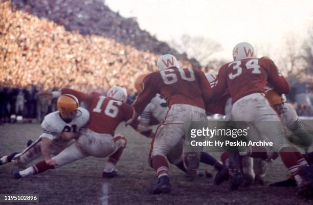 Gary Kolb of the Illinois Fighting Illini tries to block as Jerry Stalcup, Bob Zeman and Billy Hobbs of the Wisconsin Badgers go for the tackle...