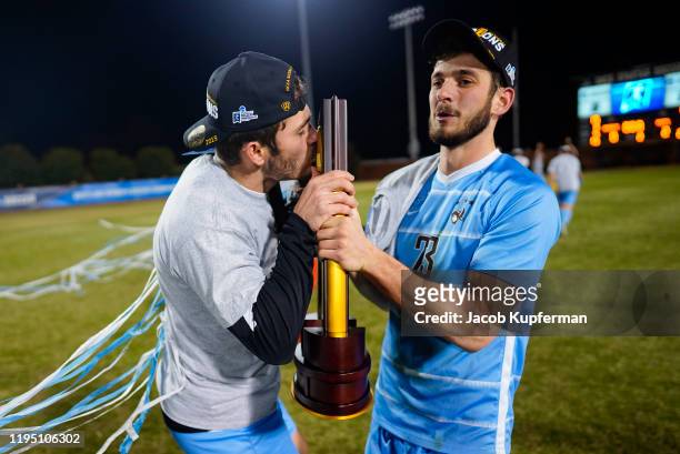 Ian Daly and Tanner Jameson of Tufts Jumbos Tufts celebrate with the trophy after defeating the Amherst Mammoths during the Division III Men's Soccer...
