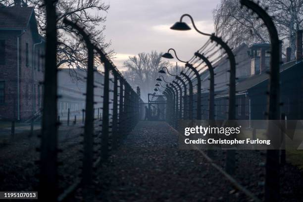 Morning fog blankets the electric fence and security lights that surround the Auschwitz I extermination camp on December 18, 2019 in Oswiecim,...