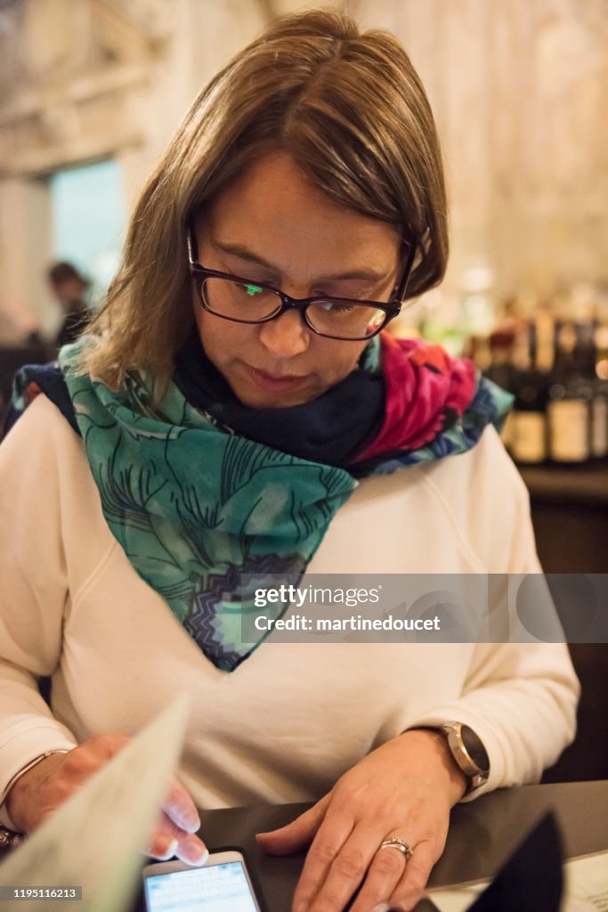 Portret van een volwassen vrouw met een drankje in de bar.