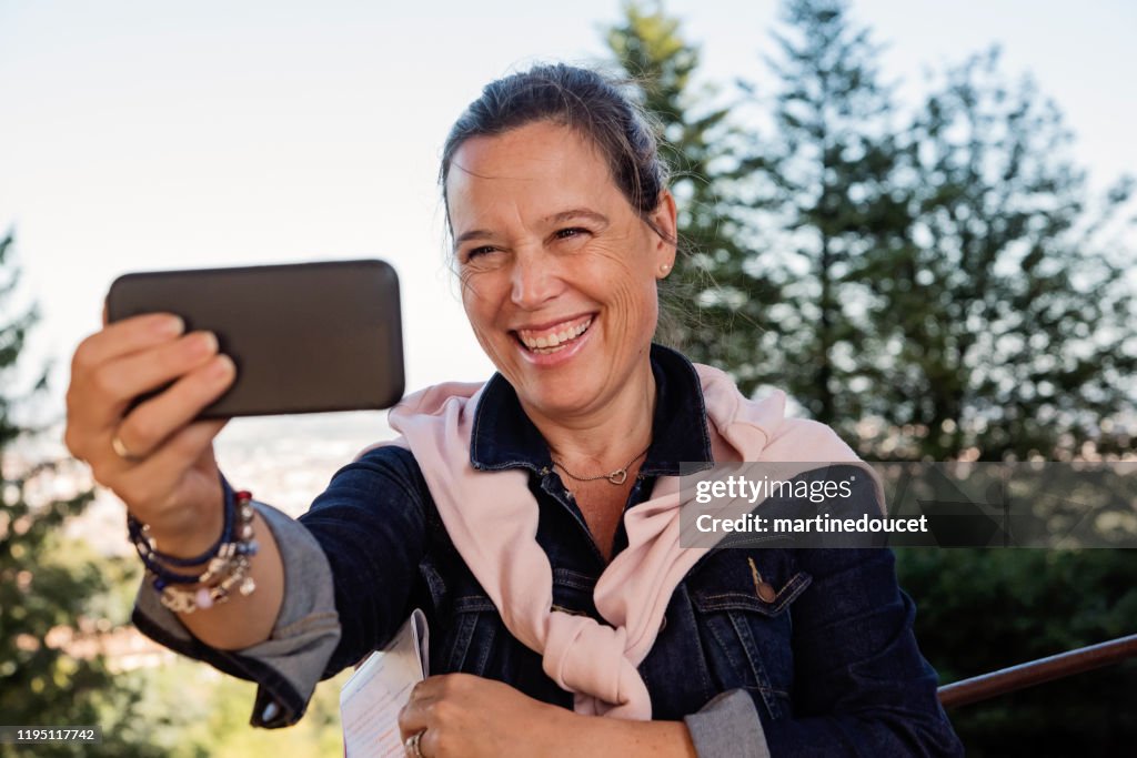 Rijpe vrouw het nemen van een selfie in de voorkant van Cityscape.