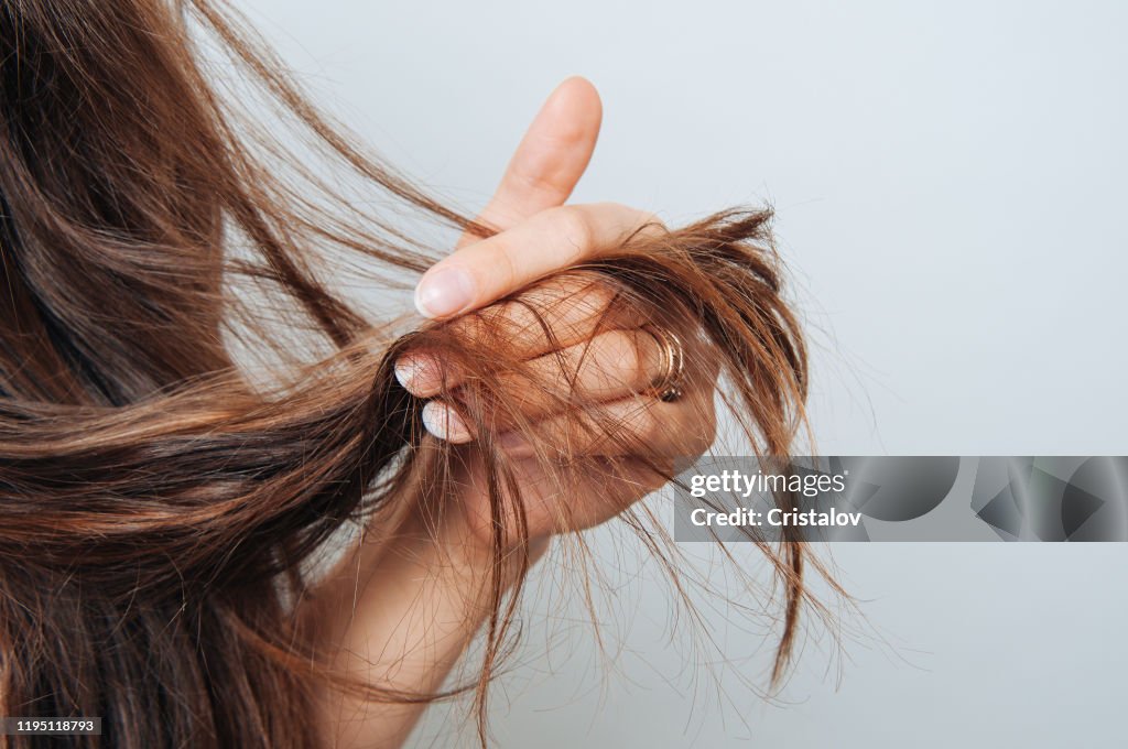 Girl holding her hair in her hand. Hair care concept. Shampoo. Haircut needed.