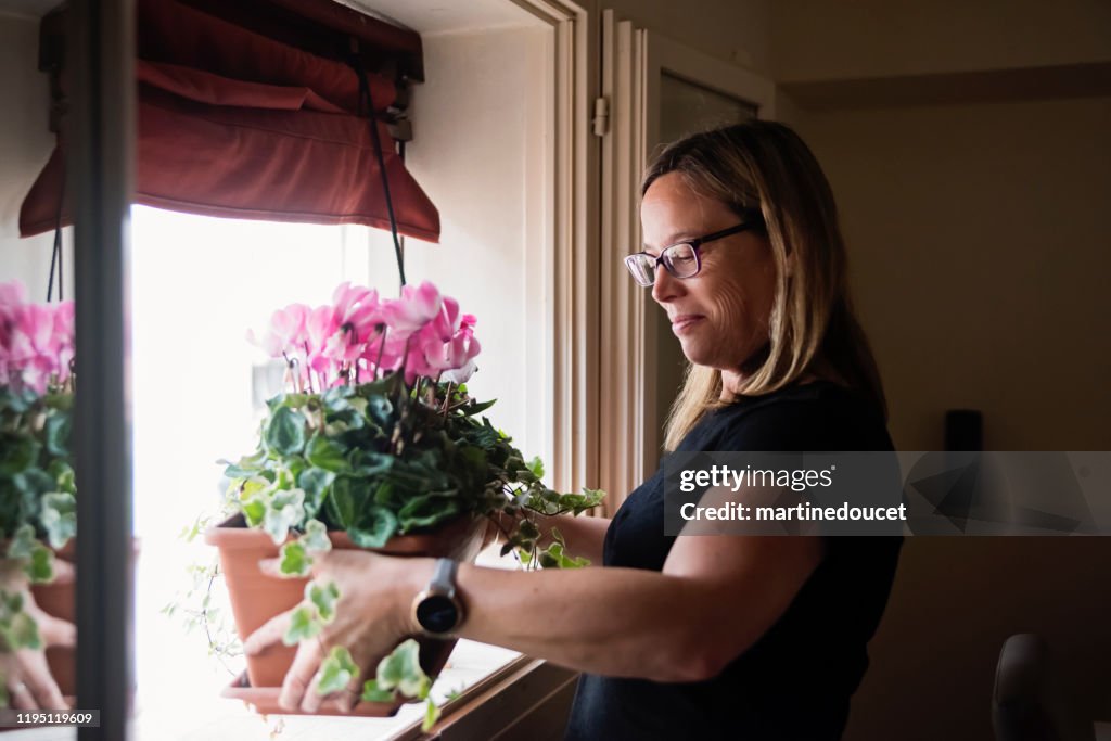 Mature woman gardening in her appartement.